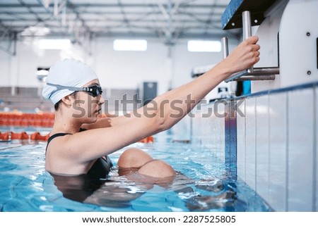 Swimming woman, ready for performance and sports with fitness, health and training for competition at indoor pool. Water sport, Asian athlete and exercise with focus and serious female swimmer