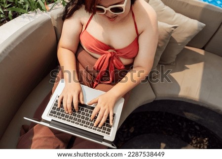 Obese Woman Vacation Traveling Laptop Technology working on laptop in in the swimming pool holiday remote online working digital Freelance work studying online e-learning.
