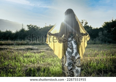 Woman in field with hidden face