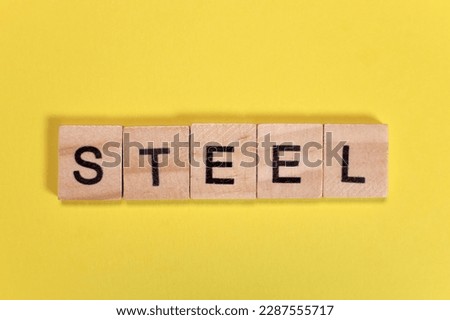 Steel word from wooden letters on yellow background
