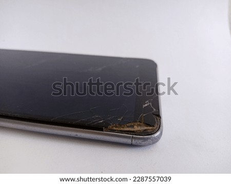 Broken smart phone with cracked screen. Broken point in the sensor. The protective film is attached with a white background
