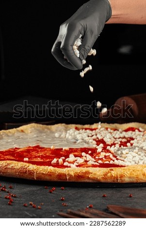 Making a pizza sprinkling dough foundation with cheese