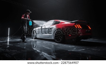 Car Wash Detailer Spraying Smart Foam to Clean the Exterior of a Tuned Red Sports Coupe at a Performance Car Dealership. Advertising Style Footage of a Professional Hand Car Wash Service Royalty-Free Stock Photo #2287564907