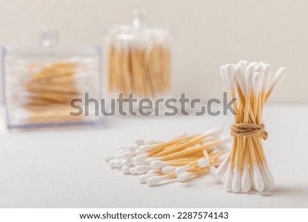 Cotton swabs on a white cement background. Bamboo cotton buds. Means for hygiene of ears. Eco-friendly materials.Hygienic cotton ear buds.