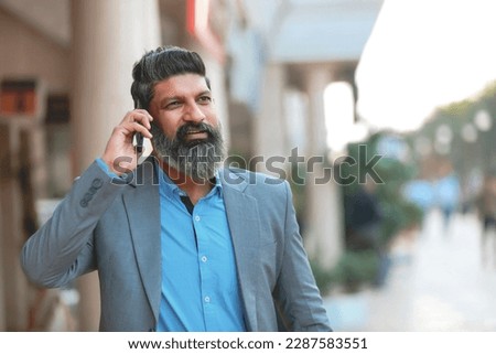 Indian businessman talking on mobilephone. Royalty-Free Stock Photo #2287583551