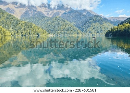 A beautiful clear lake surrounded by high mountains. Beautiful water landscape. Rest on the shore of the reservoir.