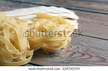 Picture of a lot of raw pasta on a wooden background