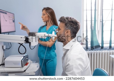 Man testing breathing function by spirometry. Diagnosis of respiratory function in pulmonary disease Royalty-Free Stock Photo #2287604453