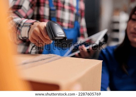 Retail storehouse employees doing inventory management while scanning packages. Postal service warehouse manager holding barcode scanner and digital tablet in arm close up Royalty-Free Stock Photo #2287605769