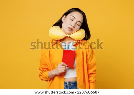 Young woman wearing summer casual clothes neck pillow hold passport ticket isolated on plain yellow background. Tourist travel abroad in free spare time rest getaway. Air flight trip journey concept Royalty-Free Stock Photo #2287606687