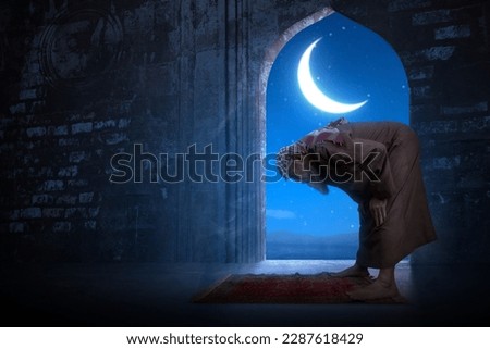Muslim man with a beard wearing keffiyeh with agal in praying position (salat) on the prayer rug inside the mosque Royalty-Free Stock Photo #2287618429