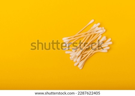 Cotton swabs on a yellow texture background. Bamboo cotton buds. Means for hygiene of ears. Eco-friendly materials.Hygienic cotton ear buds.