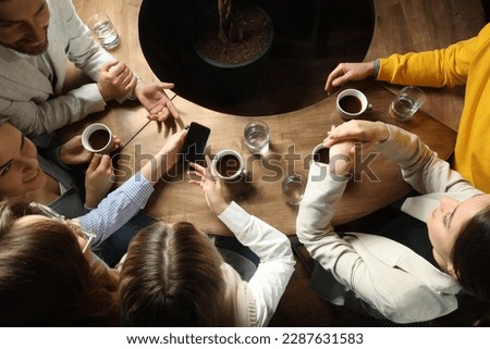 Friends with coffee spending time together in cafe, above view Royalty-Free Stock Photo #2287631583