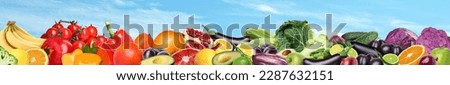 Many different fresh fruits and vegetables against blue sky with clouds. Banner design