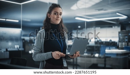 Portrait of a Happy Smiling Female, Using Laptop Computer, Looking at Camera and Smiling. Empowered Information Technology Specialist, Software Engineer or Developer Royalty-Free Stock Photo #2287651195
