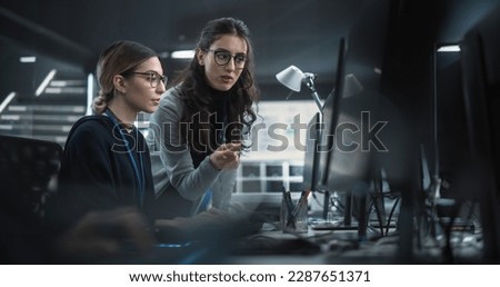 Young Multiethnic Female Software Developer Working on Computer, Discussing Project with Team Leader. Data Protection Center with Servers, Storage Hardware and Cyber Security Research Royalty-Free Stock Photo #2287651371