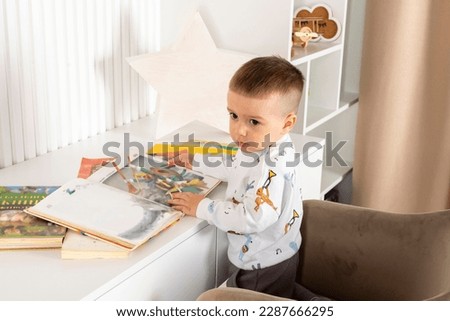 A little boy curiously looks at a children's picture book.