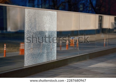 Damaged tempered glass fence. Broken glass fence with banisters. Broken guard rail on office terrace. Steel railing with damaged panel, cracks on broken tempered glass. Fencing repair Royalty-Free Stock Photo #2287680967
