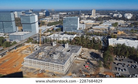 Multistory concrete building with elevator shafts under construction in Perimeter Center busy Interstate 285 highway construction metro complex office tower, Atlanta, Georgia. Aerial view modern city