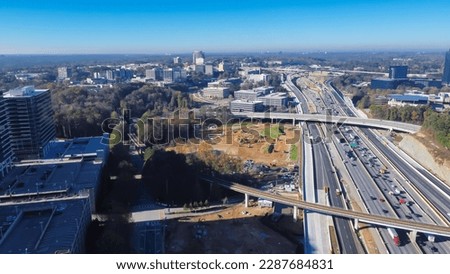 Rapid transit line rail system, elevated expressway along Perimeter Interstate 285 highway construction site, skylines office towers of Perimeter Center, Atlanta, Georgia. Aerial view metro complex