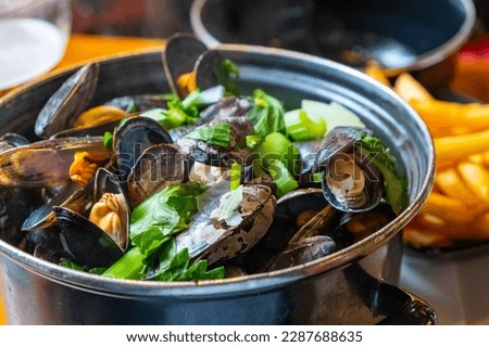 A closeup of a delicious steamed mussel casserole in a Belgian restaurant. Healthy food. Royalty-Free Stock Photo #2287688635
