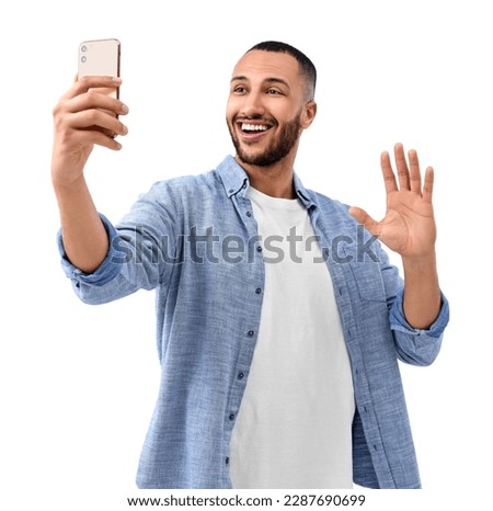 Smiling young man taking selfie with smartphone on white background Royalty-Free Stock Photo #2287690699