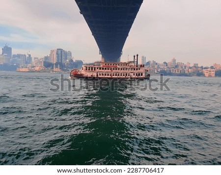 Sydney Showboats sail under the Sydney Harbor Bridge. Royalty-Free Stock Photo #2287706417