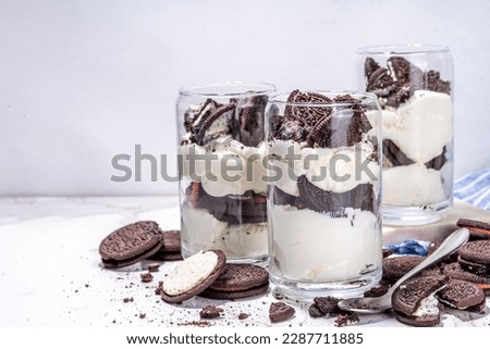 Cream and cookie layered dessert. Homemade oreo trifle, vanilla chocolate cookie layered cheese cake in glass, variation of traditional american breakfast dessert Royalty-Free Stock Photo #2287711885