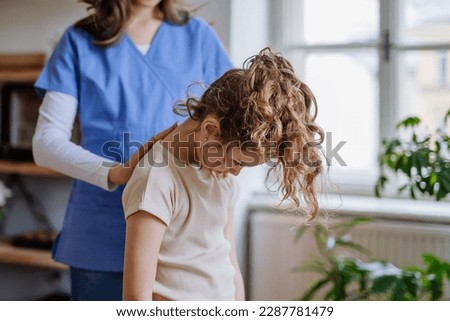 Little girl doing exercise with a nurse.