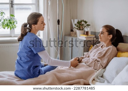 Young nurse taking care of teenage girl.