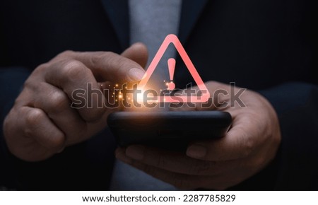 Caution in investing Warning sign, economic situation, phishing and internet security concept, businessman using smartphone with warning sign