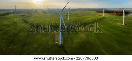 Aerial view of  windmills, agricultural green fields in the countryside in spring. Panorama view of wind farm and agriculture fields. Environmental stewardship and sustainability in agriculture. Royalty-Free Stock Photo #2287786503