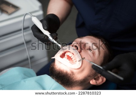 Doctor dentist treats the teeth of a patient in a hospital. Disposable rubber mouth opener. Royalty-Free Stock Photo #2287810323