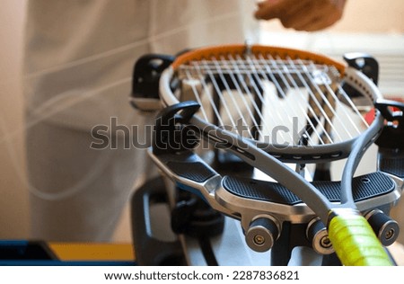 close-up of the hands of a master who pulls the strings on a tennis racket using a special machine Royalty-Free Stock Photo #2287836821