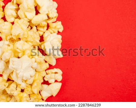 Popcorn on a red background. Sweet popcorn on red. Close-up.