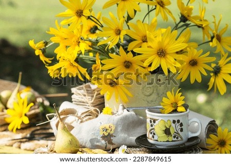 Blooming Jerusalem artichokes plant flowers in vase, in nature background, still life with  flowering Jerusalem artishokes on yellow table Royalty-Free Stock Photo #2287849615