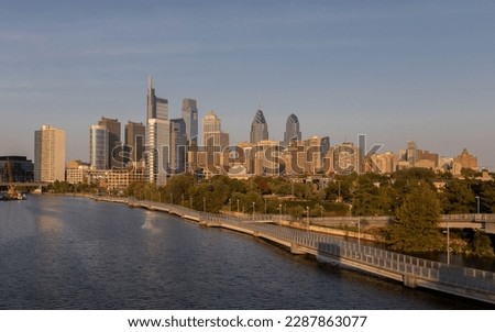 Philadelphia Downtown skyline with the Schuylkill river. Beautiful Sunset Light. Schuylkill River Trail in Background. City skyline glows under the beautiful sunset light. PA, USA.