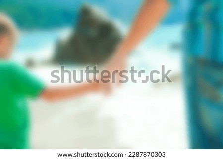 Hands of a happy parent and child on the seashore on a journey trip in nature