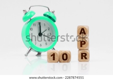 Business and holidays concept. On a white background there is an alarm clock and a calendar with the inscription - April 10
