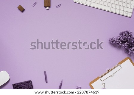The workspace of a blogger or freelancer Flat lay with a keyboard, notebooks and lilac branches, stationery on a lilac background with a copy space