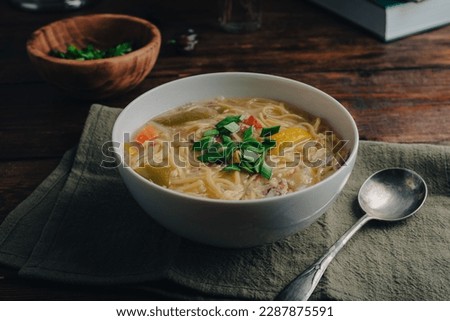 White Bowl of Noodle Soup with Vegetables and Duck Meat