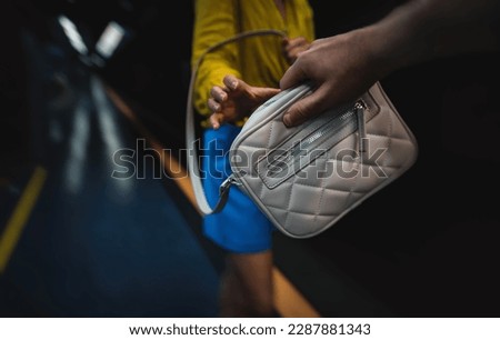 Thief steals a bag from a woman in the subway. Royalty-Free Stock Photo #2287881343