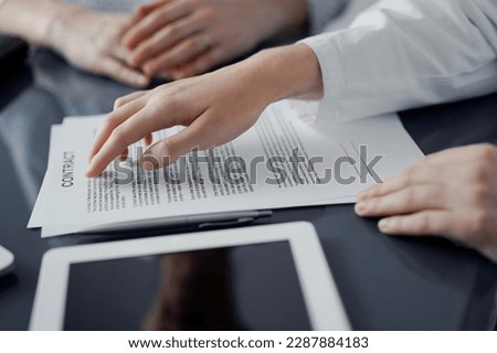 Business people discussing contract signing deal while sitting at the glass table in office, closeup. Partners or lawyers working together at meeting. Teamwork, partnership, success concept.
