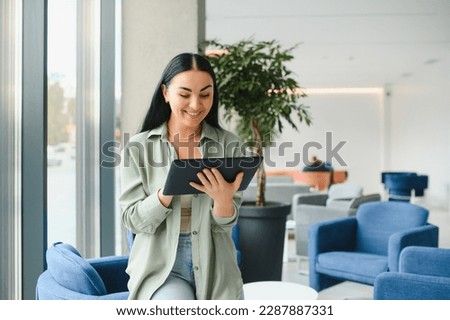 Traveler tourist woman with headphones working on laptop, spreading hands during video call while waiting in lobby hall at airport. Passenger traveling abroad on weekends getaway. Air flight concept.