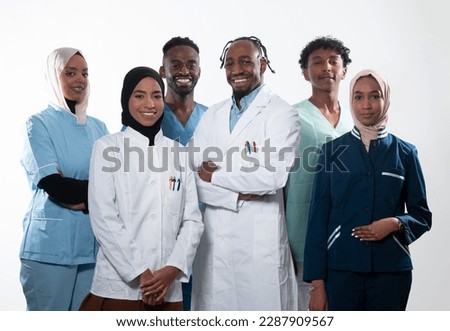 Team or group of a doctor, nurse and medical professional coworkers standing together. Portrait of diverse healthcare workers looking confident. Middle Eastern and African, Muslim medical team. 