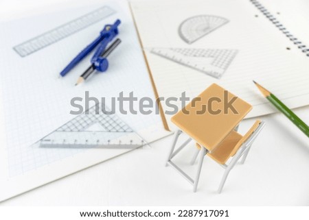A study desk with a ruler, notebook, graph paper, and toys. image of mathematics