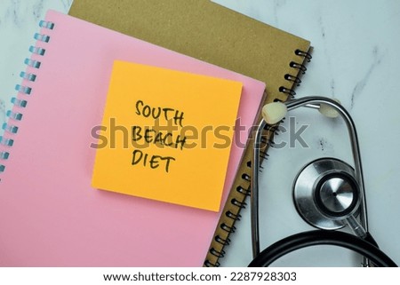 Concept of South Beach Diet write on sticky notes with stethoscope isolated on Wooden Table.