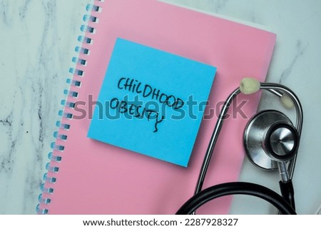 Concept of Childhood Obesity write on sticky notes isolated on Wooden Table. Royalty-Free Stock Photo #2287928327