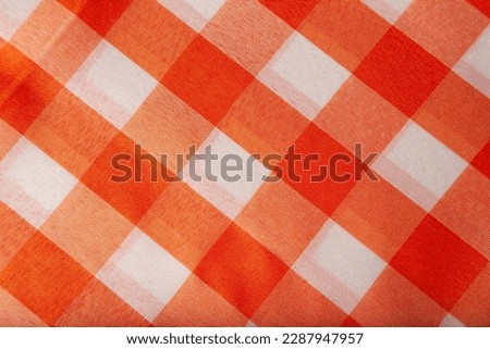 Checkered tablecloth or picnic texture, plaid, clothes. Fabric geometric background, retro textile design. Orange and white plaid. Royalty-Free Stock Photo #2287947957