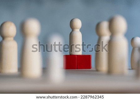 Wooden figures and peg dolls standing on the red podium 1st positions of wooden cube blocks. Ranking and strategy concept. Leadership concept and business strategy. Selective focus Royalty-Free Stock Photo #2287962345